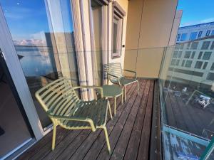 a balcony with two chairs and a window at Luxury penthouse apt with amazing views in Svolvær