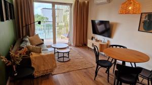 una sala de estar con un sofá y una mesa en Plażowa 108, en Grzybowo