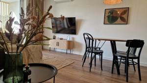 Una sala de estar con una mesa y sillas y un televisor. en Plażowa 108, en Grzybowo