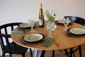 una mesa de madera con copas y una botella de vino en Plażowa 108, en Grzybowo