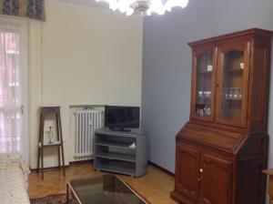 a living room with a large wooden cabinet and a television at Relax time in Biella