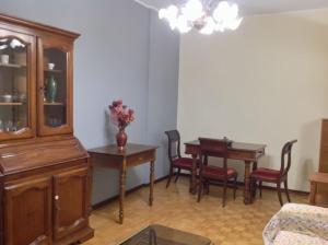 a living room with a wooden cabinet and a table at Relax time in Biella