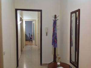 a hallway with a mirror and a table in a room at Relax time in Biella +1 photo