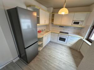 a kitchen with white cabinets and a refrigerator at Guest room - Monteurzimmer im Kestert (56348) in Kestert