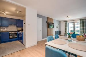 a kitchen and living room with a table and chairs at Citygate Central Apartments in Belfast