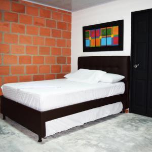 a bed in a room with a brick wall at GREEN APARTMEN "El Jardín" in Girón