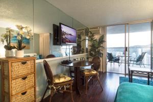 sala de estar con mesa de comedor y TV en Island Colony 4309 - 30-Night Minimum en Honolulu