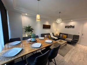 a dining room table with chairs and a living room at Central Station Comfort, Your Cozy Home with free Parking in Salzburg