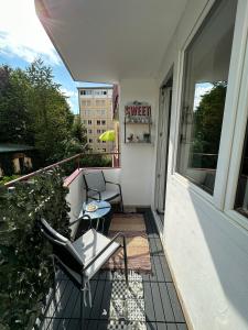 einen Balkon mit 2 Stühlen und einem Tisch auf einem Gebäude in der Unterkunft Central Station Comfort, Your Cozy Home with free Parking in Salzburg