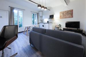 - un salon avec un canapé et une table dans l'établissement APPARTEMENT Intra Muros AU CALME et Bien Placé, à LʼIsle-sur-la-Sorgue