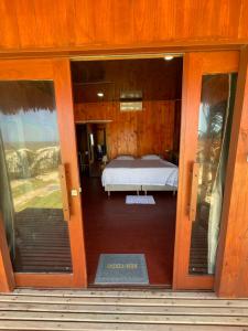 a door to a bedroom with a bed in it at Delta Chalé in Tutóia