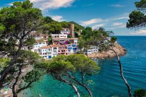 a group of houses on a hill next to the ocean at Casa Viva Begur in Begur