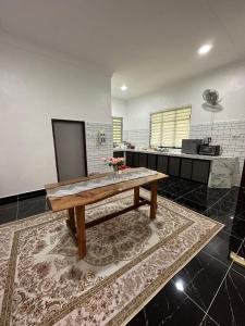 a kitchen with a wooden table in a room at Rania Riverview Guesthouse in Kuala Berang