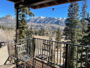 a balcony with two chairs and a view of mountains at Purgatory Resort Ski In Ski Out in Durango