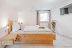 a bedroom with a bed and a wooden bench at Landhaus Plainer in Innsbruck