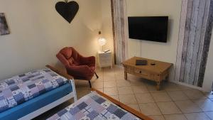 - une chambre avec un lit, une chaise et une table dans l'établissement Haus Adelheid, à Weil am Rhein