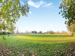 a field of grass with a building in the background at Downsview Cottage in Lyminster