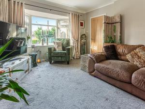 a living room with a couch and a tv at Tean House in Totmonslow