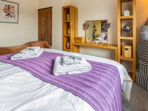 a bedroom with a purple blanket on a bed at Tean House in Totmonslow