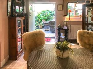 comedor con mesa, sillas y puerta en Garden Cottage en Helmsley