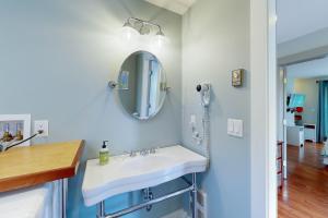 uma casa de banho com um lavatório branco e um espelho. em The Mermaid Suite em Vineyard Haven