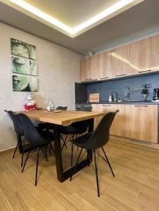 eine Küche mit einem Holztisch und schwarzen Stühlen in der Unterkunft Suncana Planina Glory-Kop in Kopaonik