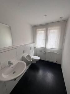 a white bathroom with a sink and a toilet at Gepflegte 4,5 Zimmer Wohnung bis 8Pers. in Oberstenfeld