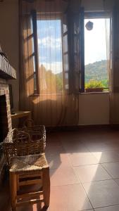 a room with a chair and two large windows at Al Viento, Alojamiento & Turismo Rural Prádena del Rincón in Prádena del Rincón