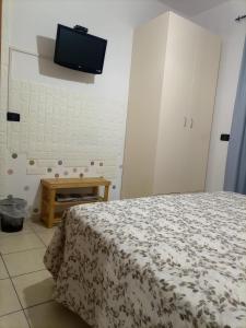 a bedroom with a bed and a tv on the wall at La Villetta in Rende