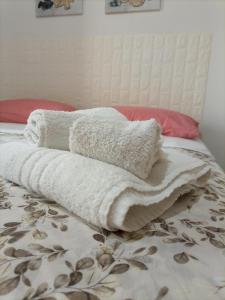 una pila de toallas sentadas encima de una cama en La Villetta, en Rende