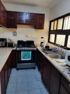 een keuken met een fornuis en een wastafel bij Bella Vista Apartment, Oasis Residential in Santo Domingo