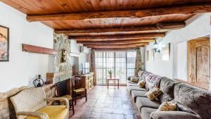 una sala de estar con un sofá grande y techos de madera. en Casita Sebastian Benalauria by Ruralidays, en Benalauría
