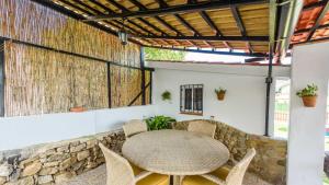 una mesa y sillas en un patio con una pared de piedra en Casita Sebastian Benalauria by Ruralidays, en Benalauría