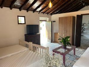 Schlafzimmer mit einem Bett, einem TV und einem Tisch in der Unterkunft Casa Granada in Estepona