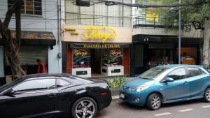 twee auto's geparkeerd voor een fastfoodrestaurant bij 1940s B&B Mi casa, tu casa Roma Norte in Mexico-Stad