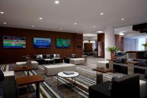vestíbulo con sofás, sillas y TV en Long Island Marriott Hotel en Uniondale