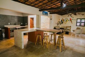 a kitchen with a large island with bar stools at Vila Kapa in Parajuru