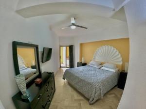 a bedroom with a bed and a dresser and a mirror at Oceanview Condo Vela Vallarta condo in Puerto Vallarta