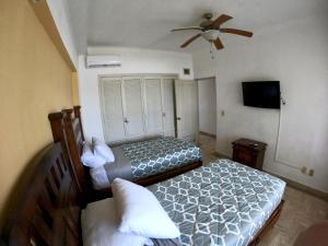 a bedroom with two beds and a ceiling fan at Oceanview Condo Vela Vallarta condo in Puerto Vallarta +18 photos