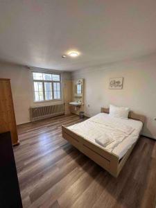 1 dormitorio con 1 cama grande y suelo de madera en 220qm2*10 Einzelzimmer*2Bäder*2WCs*Monteurzimmer Ludwigsburg Heilbronn Backnang, en Oberstenfeld