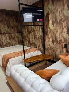 a room with two beds and a flat screen tv at Lindo e aconchegante in Bento Gonçalves