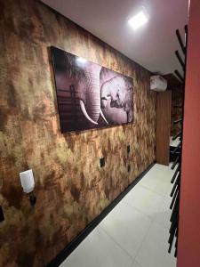 a room with a wall with a picture of an elephant at Lindo e aconchegante in Bento Gonçalves