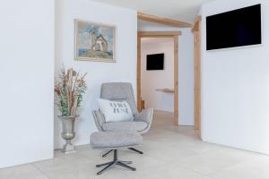 a living room with a chair and a television at Landhaus Plainer in Innsbruck