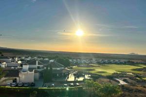 uma vista para um campo de golfe com o pôr-do-sol em Magnifique penthouse ensoleillé sur golf em Baños y Mendigo