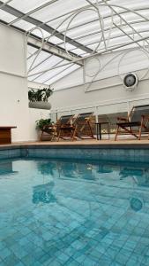 a swimming pool with two chairs and a table at Hotel Gumz in Balneário Camboriú