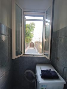 La salle de bains est pourvue d'une fenêtre et d'un lave-linge. dans l'établissement Casa cuticchia, à Castel di Tusa