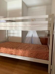 a white bunk bed with an orange comforter on it at La Mongie T3 Duplex 8 personnes vue sur les pistes in Bagnères-de-Bigorre