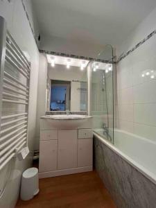 a bathroom with a tub and a sink and a shower at La Mongie T3 Duplex 8 personnes vue sur les pistes in Bagnères-de-Bigorre