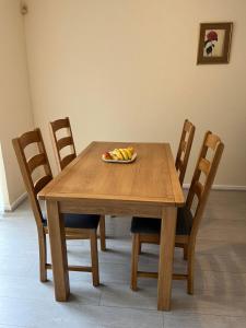 a wooden table with chairs and a plate of fruit on it at The Dunstable House in Houghton Regis