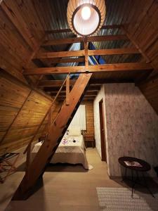 een zolderkamer met een bed en een houten plafond bij Solita beach bungalow - kite spot in Macau